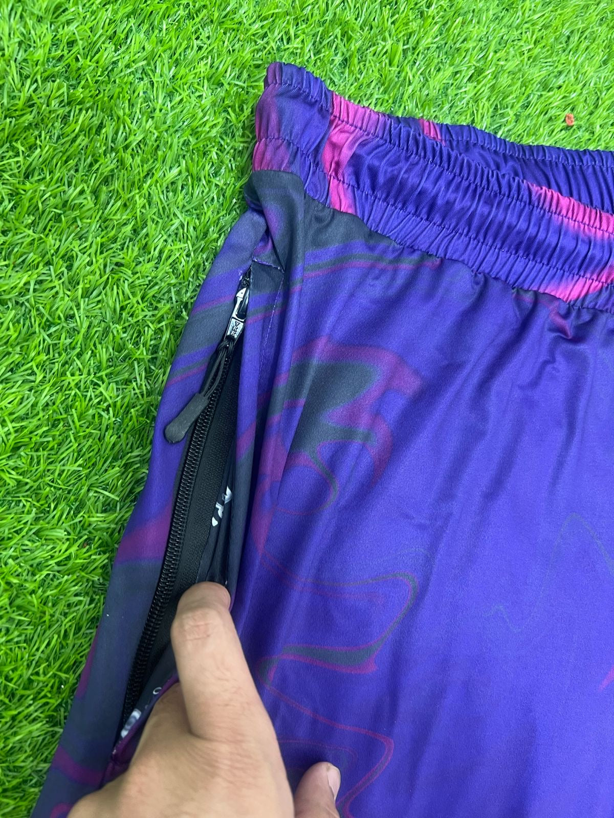 Bright neon waves pattern on Drip Drop Labs parachute pants with a loose, comfortable fit and vibrant design.