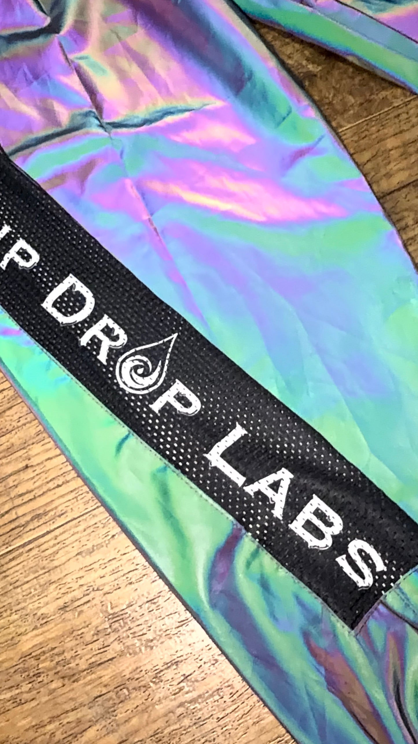 Reflective parachute pants by Drip Drop Labs featuring shiny, lightweight fabric and adjustable waistband for a trendy streetwear look.