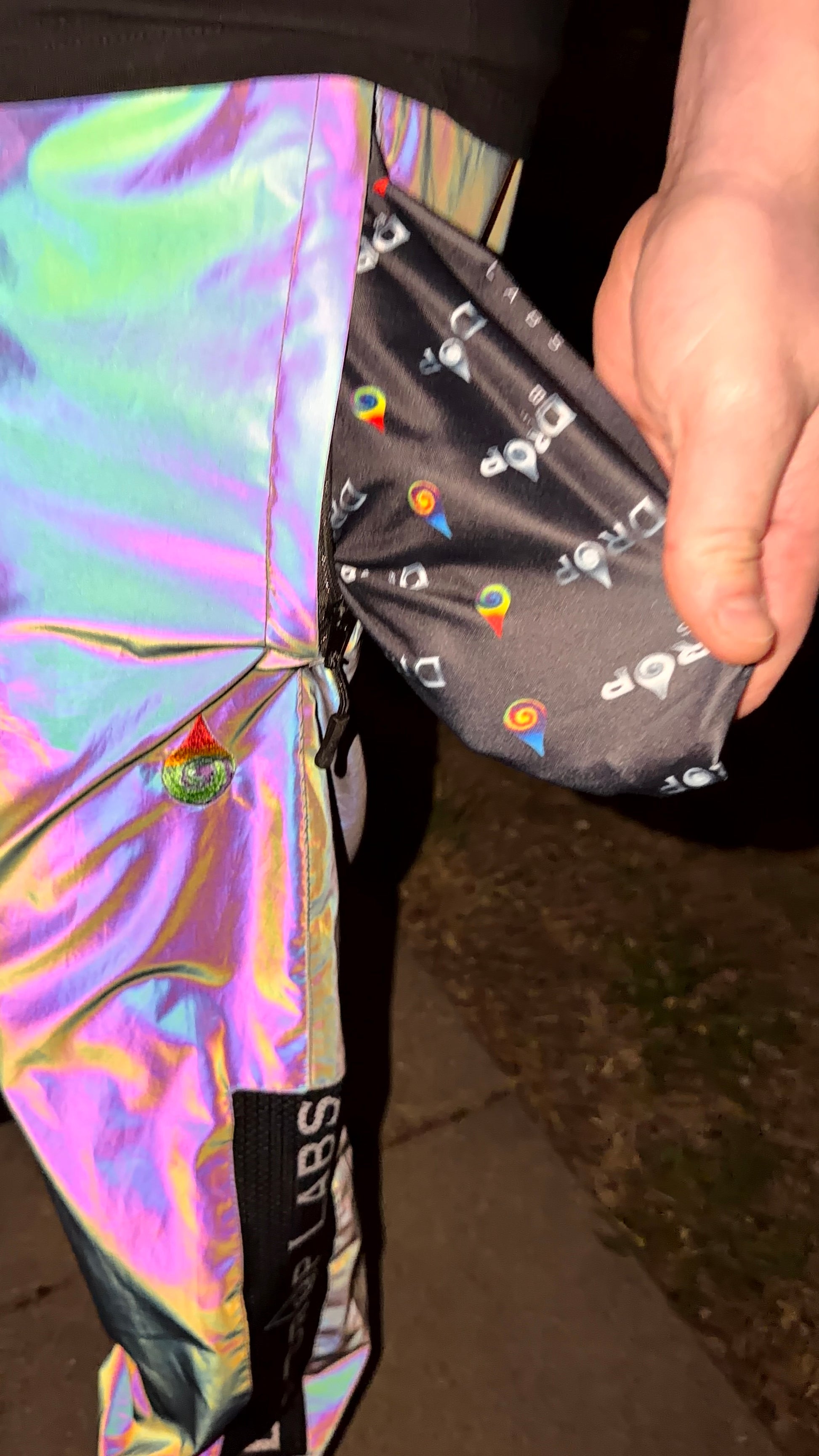Reflective parachute pants by Drip Drop Labs featuring shiny fabric, loose fit, and adjustable waistband for a stylish streetwear look.