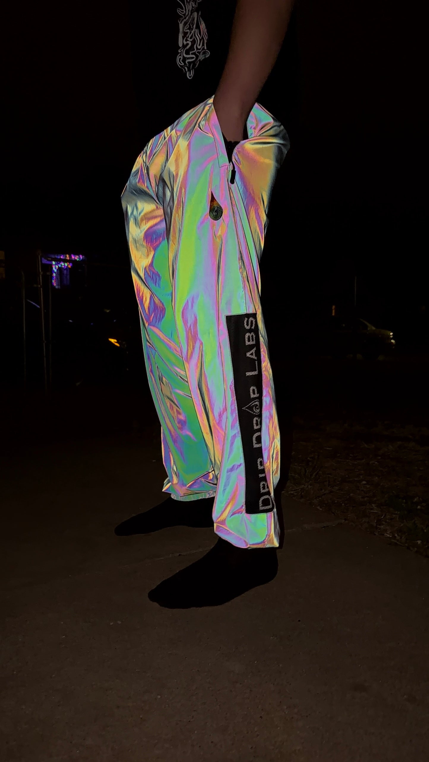 Reflective parachute pants by Drip Drop Labs featuring shiny, lightweight fabric and relaxed fit for stylish urban wear.