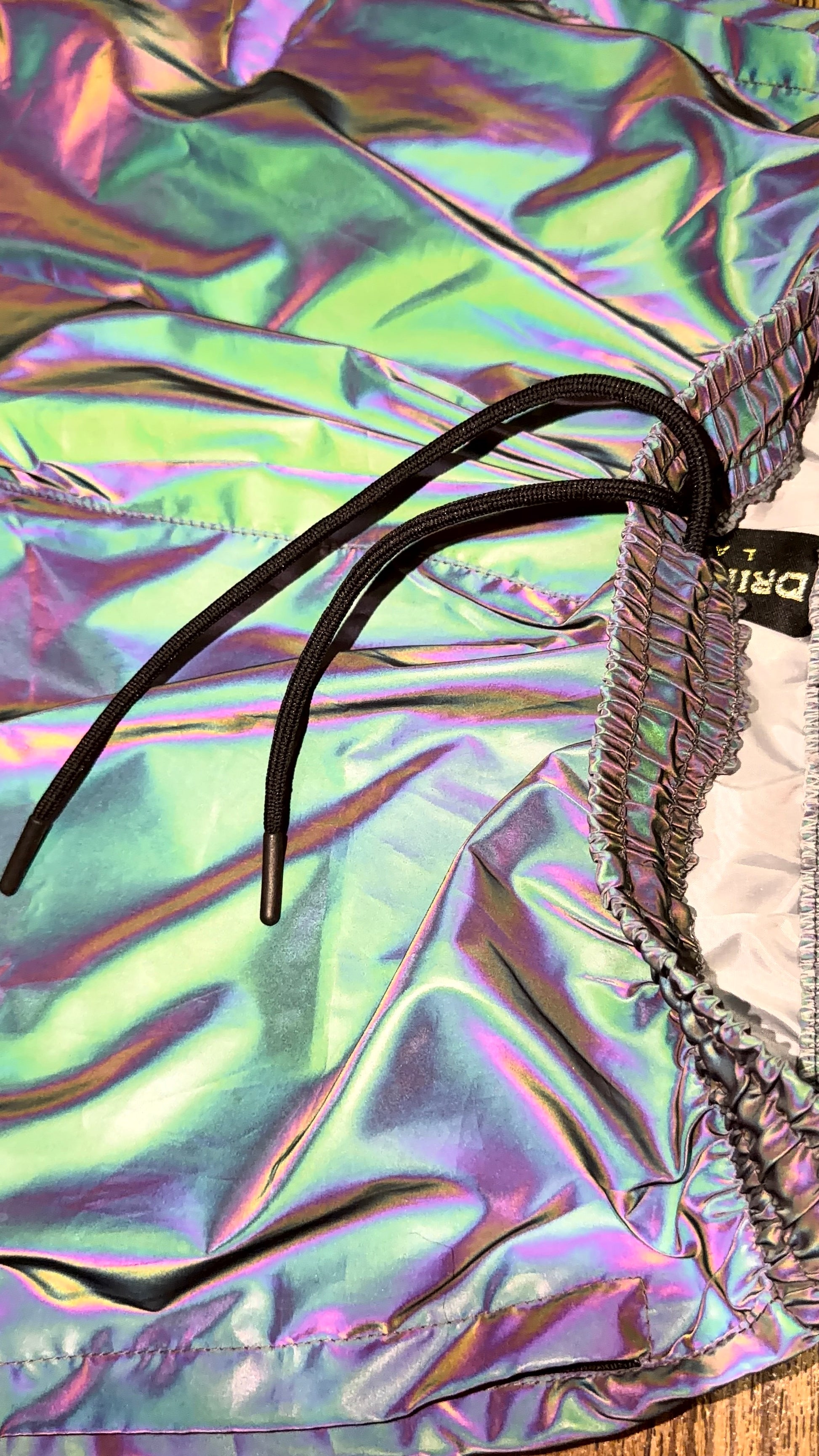 Reflective parachute pants from Drip Drop Labs featuring shiny, lightweight fabric and adjustable waistband for a stylish fit.