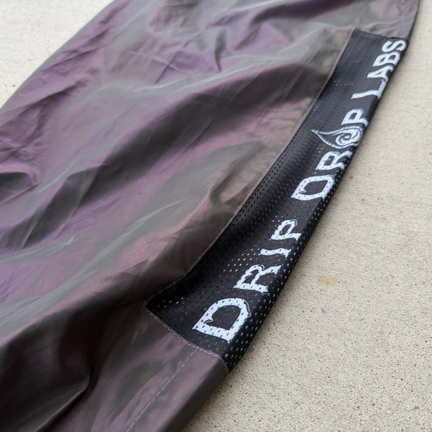 Reflective parachute pants by Drip Drop Labs featuring shiny, lightweight fabric and adjustable waistband for a modern streetwear look.
