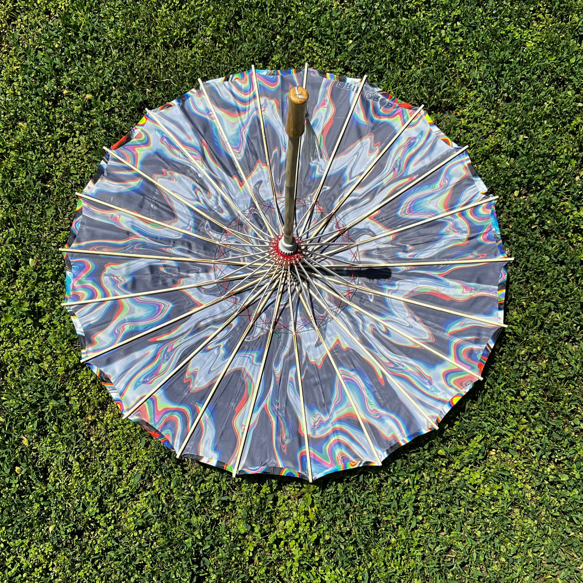 Chromatic Shadow OG parasol by Drip Drop Labs featuring a vibrant, multicolored canopy and sturdy handle for stylish sun protection.
