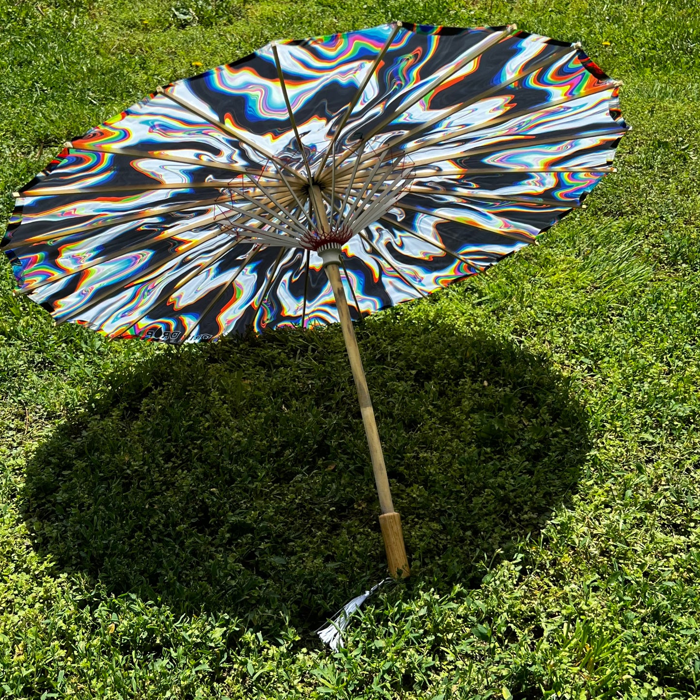 Drip Drop Labs Chromatic Shadow OG Parasol with vibrant, multicolored fabric and black handle, designed for stylish shade.