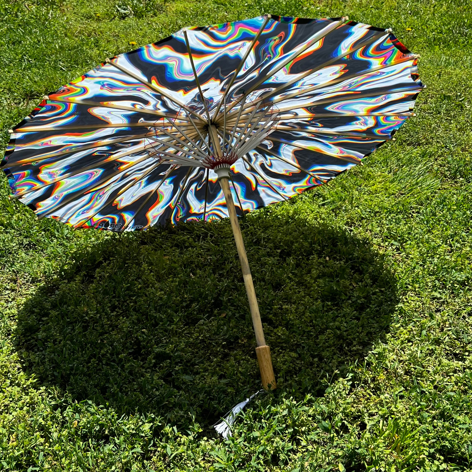 Drip Drop Labs Chromatic Shadow OG Parasol with vibrant, multicolored fabric and black handle, designed for stylish shade.