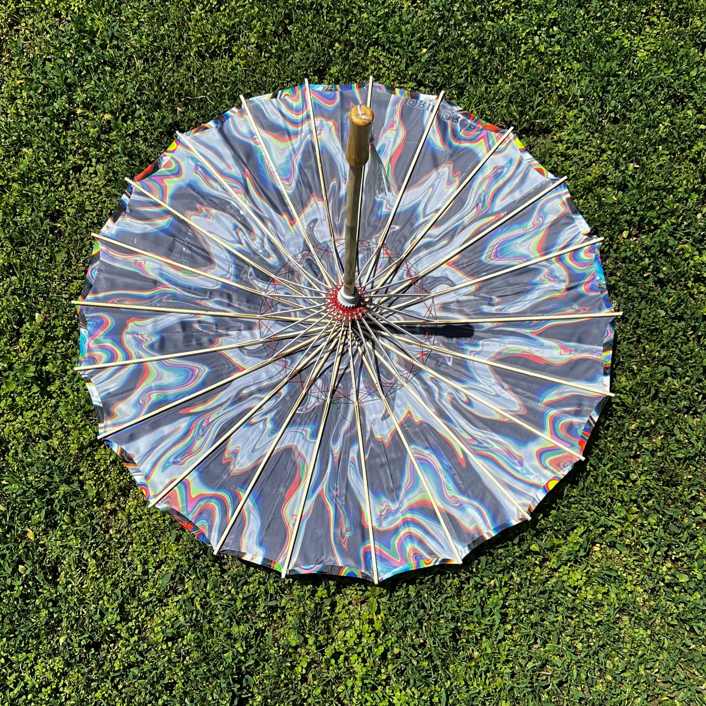 Chromatic Shadow OG parasol by Drip Drop Labs featuring a vibrant, multicolored canopy and sturdy handle for stylish sun protection.