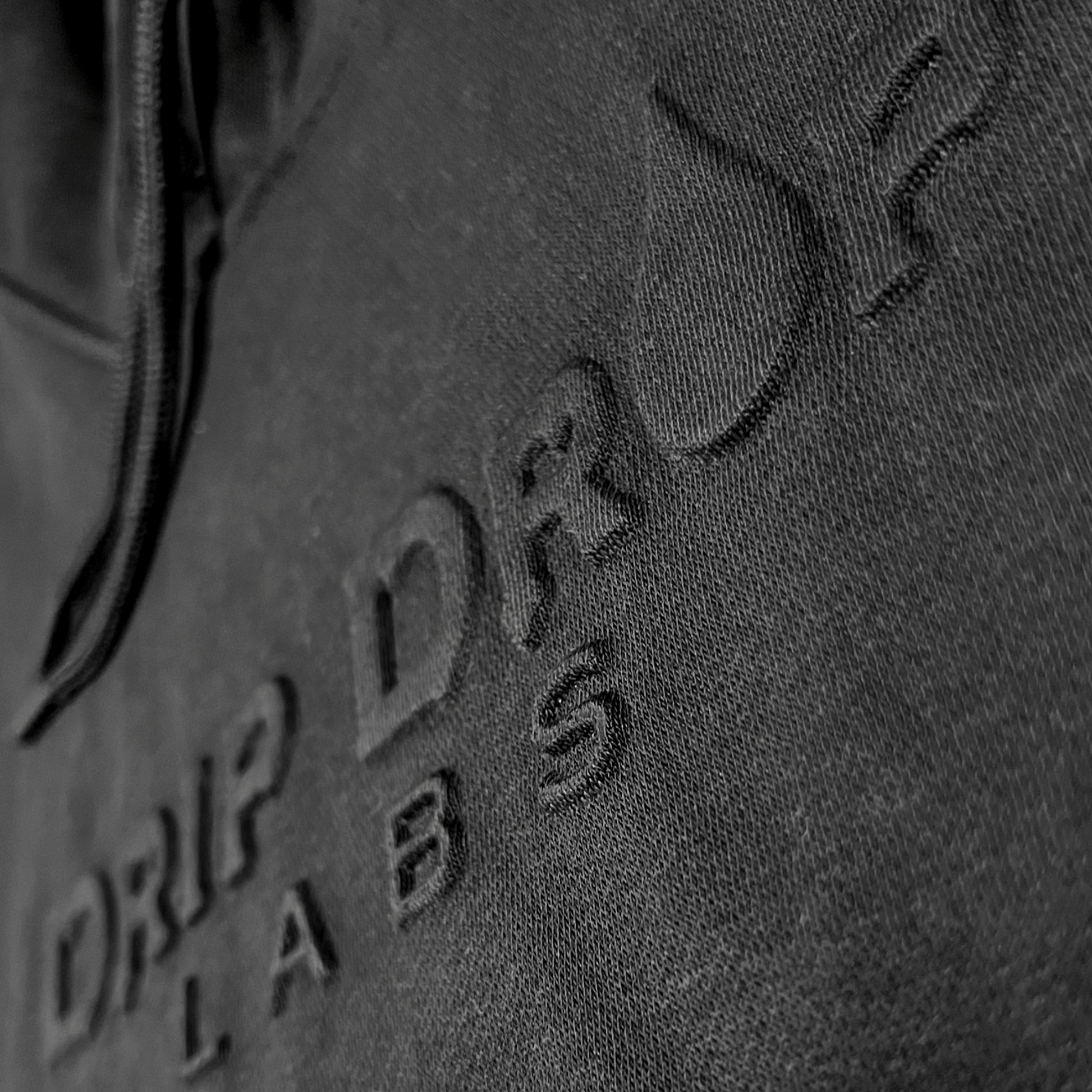 Drip Drop Labs embossed athletic hoodie in black with textured logo detailing and a comfortable fit.