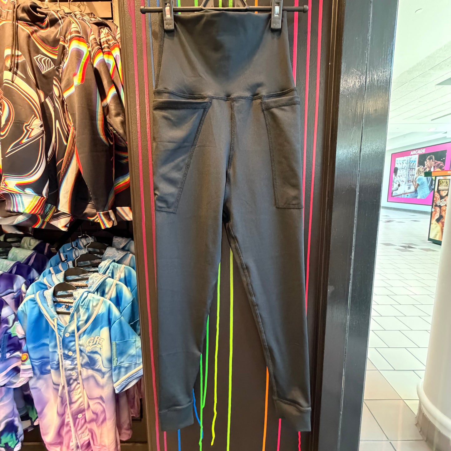 Black Drip Drop Labs leggings with abstract purple and pink patterns, fitted and high-waisted, made from stretchy fabric.