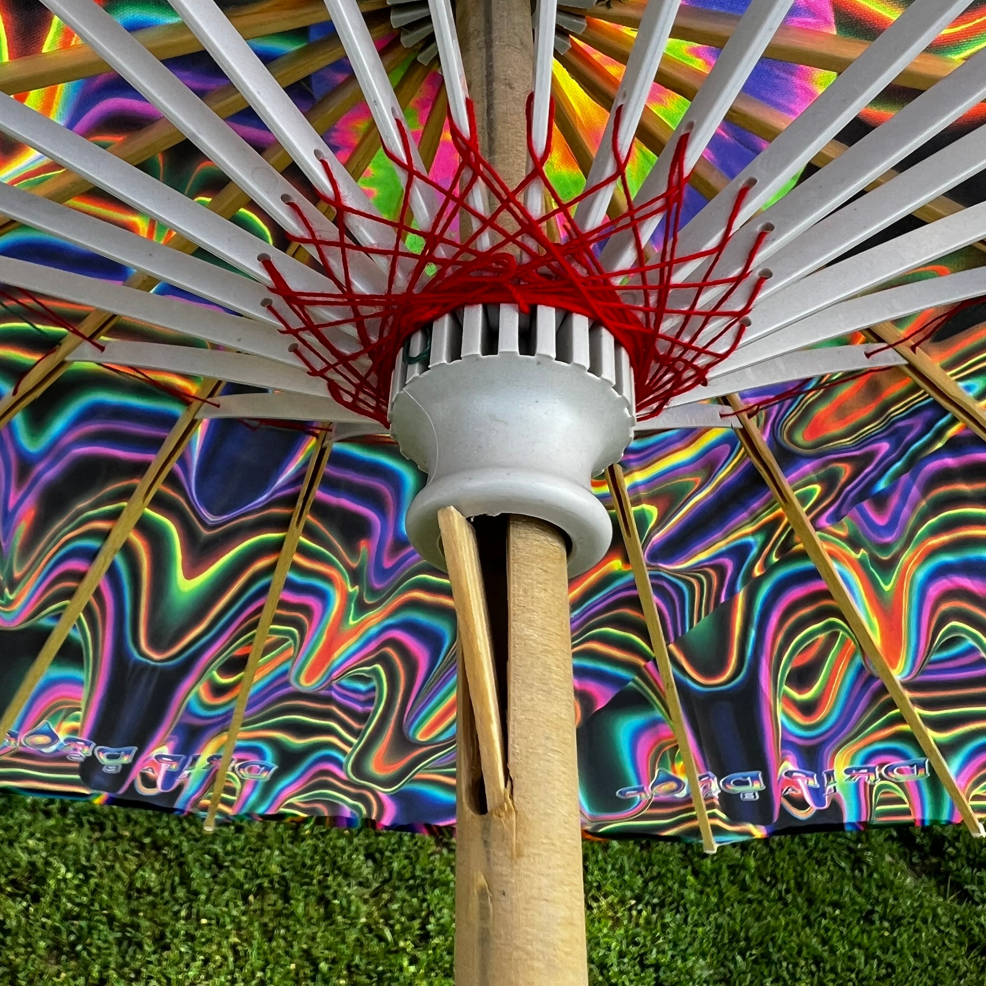Drip Drop Labs OG Parasol with vibrant, colorful canopy and wooden handle, open and displayed outdoors.