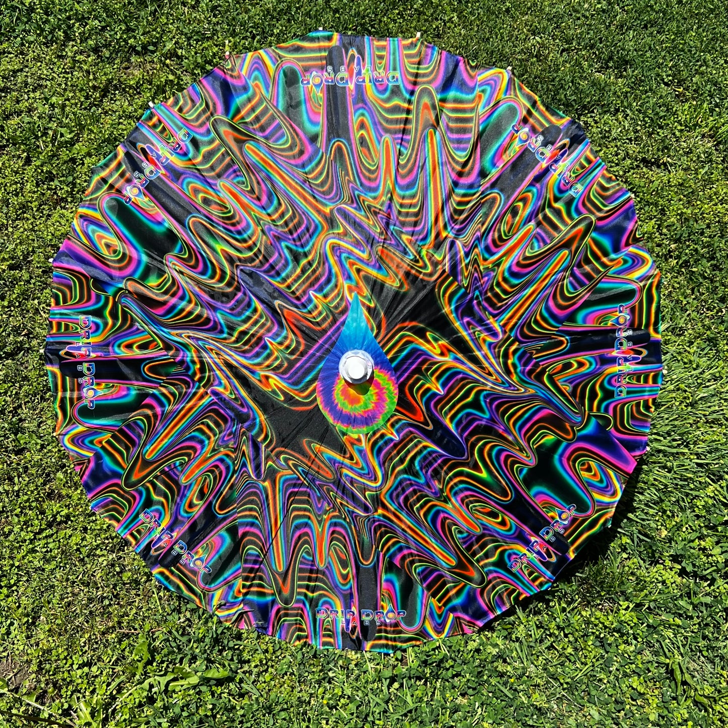 Drip Drop Labs OG Parasol featuring vibrant fabric and wooden handle, showcasing a stylish parasol for sun protection.