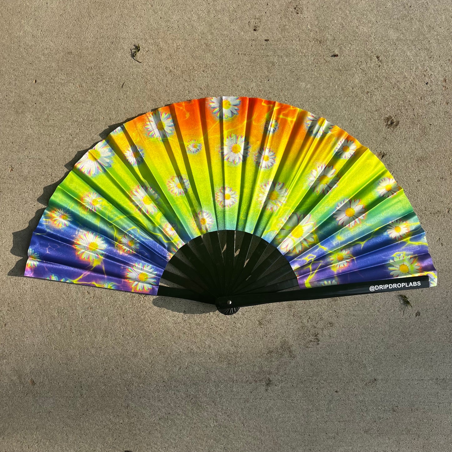 Electric Flower Glow Fan by Drip Drop Labs featuring a vibrant, illuminated flower-shaped fan with colorful glow effects.