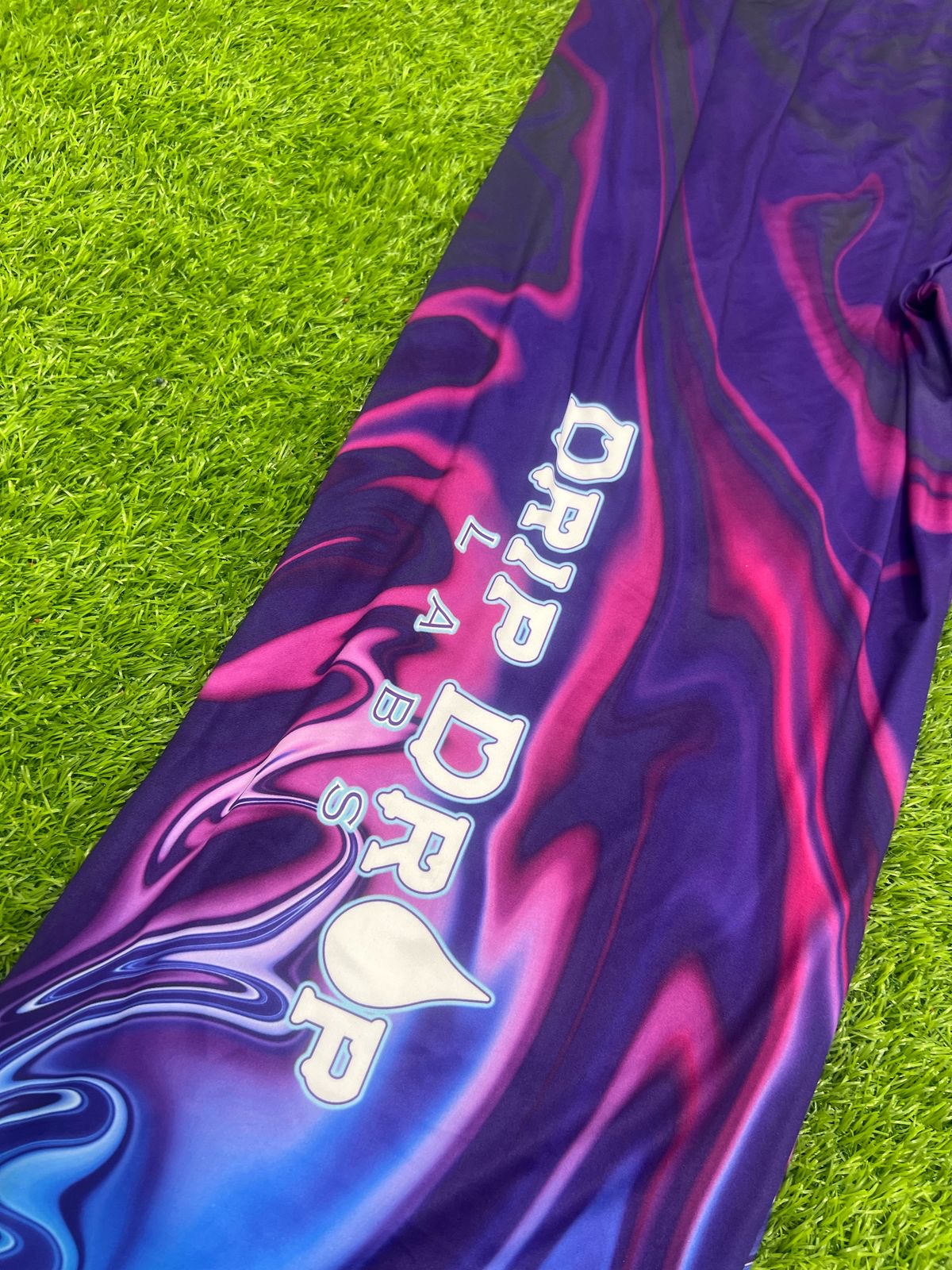 Bright neon waves design on Drip Drop Labs parachute pants with a loose, comfortable fit and vibrant colors.