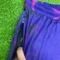 Bright neon waves pattern on Drip Drop Labs parachute pants with a loose, comfortable fit and vibrant design.