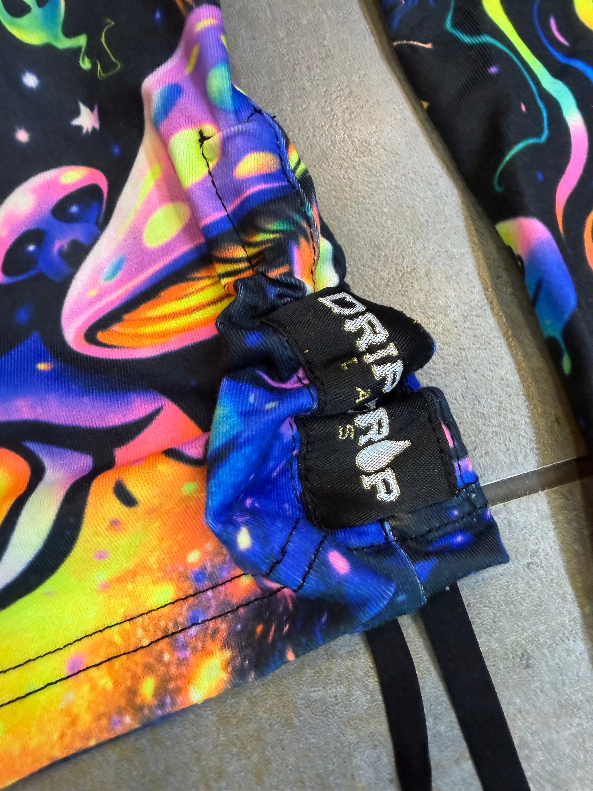 Rainbow Portal Hooded Rave Romper by Drip Drop Labs featuring vibrant psychedelic patterns and a hood, perfect for festival wear.
