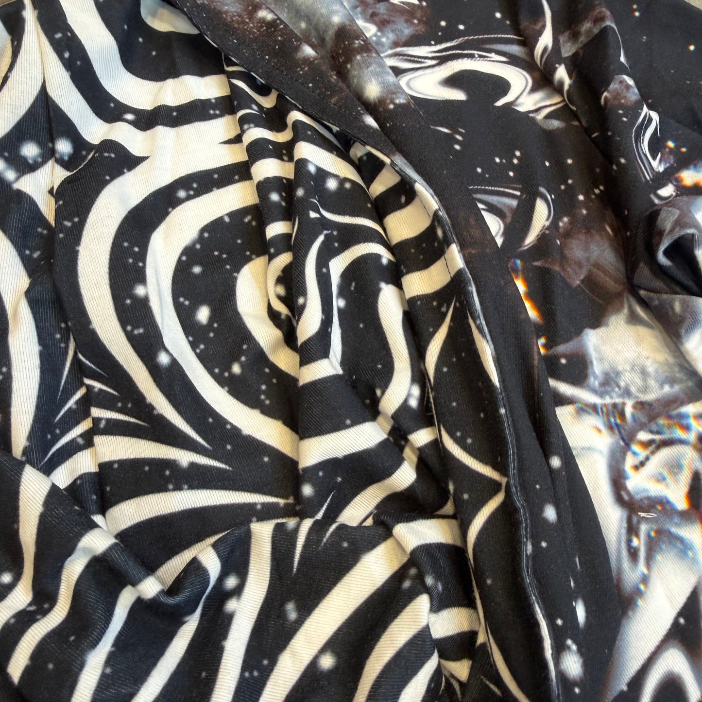 Dark galactic-themed hooded rave romper by Drip Drop Labs, featuring a cosmic print and festival-ready fit.