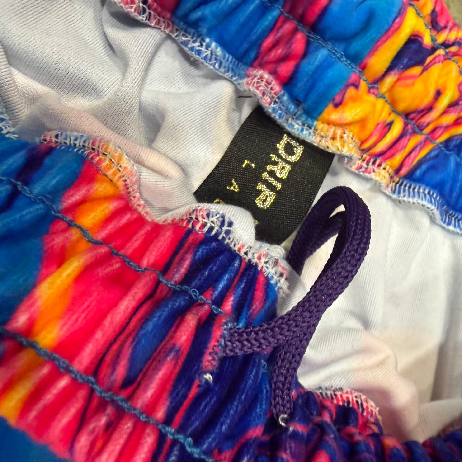 Velvet Sunset Drip parachute pants by Drip Drop Labs featuring vibrant sunset colors and relaxed, loose fit design.