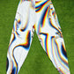 White parachute pants by Drip Drop Labs featuring a loose fit and adjustable drawstrings, styled for casual wear.