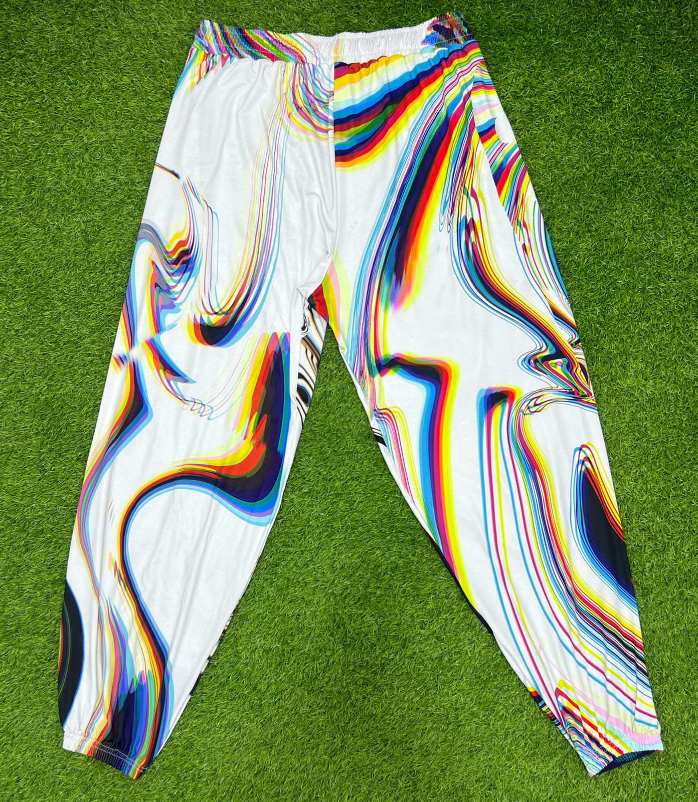 White parachute pants by Drip Drop Labs featuring a loose fit and adjustable drawstrings, styled for casual wear.