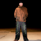 Model wearing Xenotype parachute pants in urban streetwear setting
