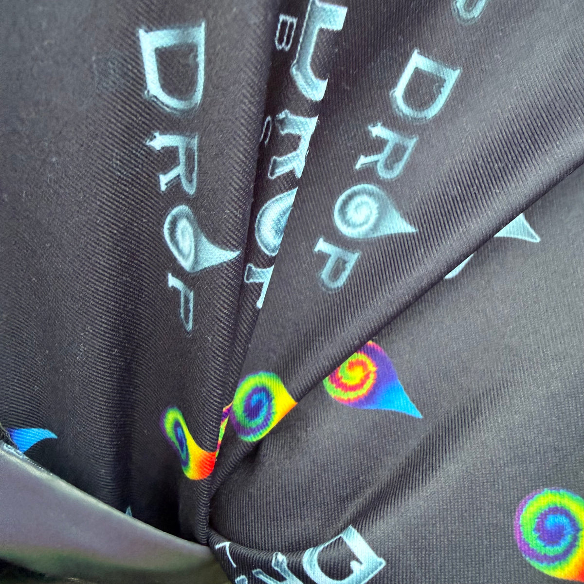 Reflective parachute pants by Drip Drop Labs featuring shiny fabric, adjustable waistband, and tapered design for a sporty look.