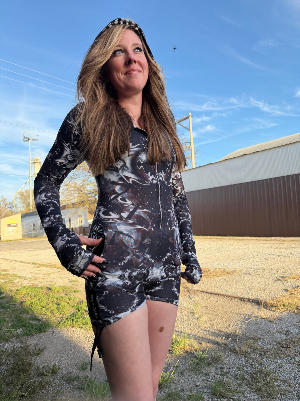 Dark galactic rave romper with hood from Drip Drop Labs featuring vibrant space-themed patterns and luminous fabric details.