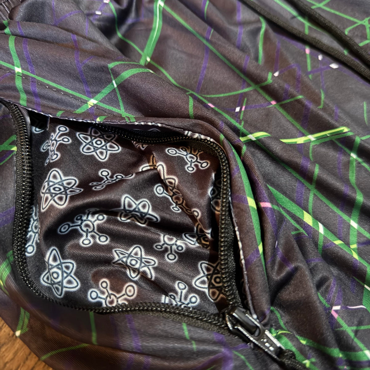 Close-up of pants with a geometric pattern and deep zipper pockets