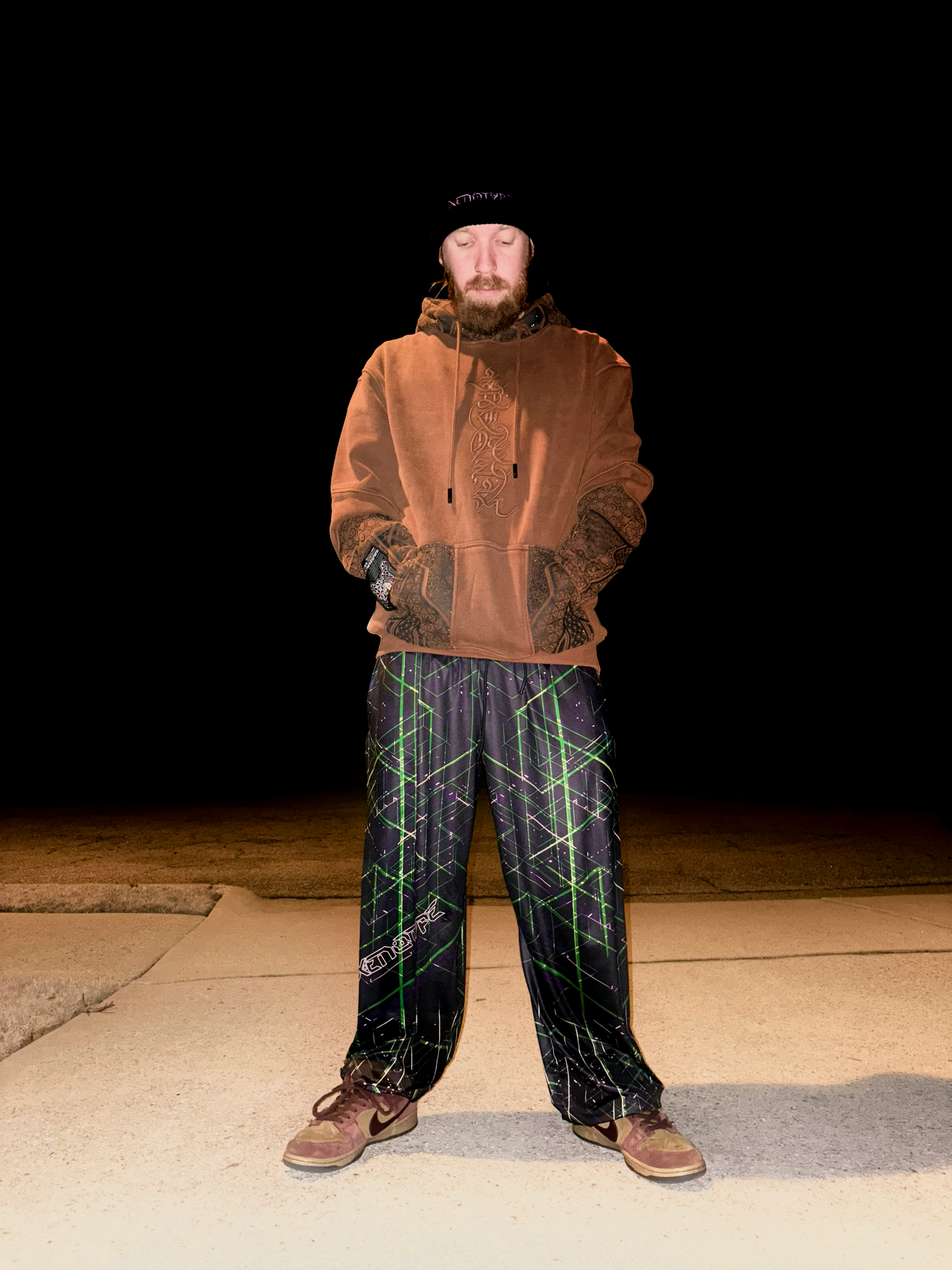 Model wearing Xenotype parachute pants in urban streetwear setting