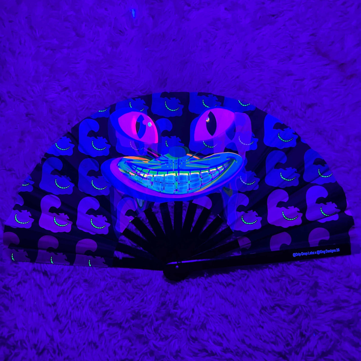 CheshireDrip Glow Fan by Drip Drop Labs with colorful LED lights, portable handheld fan for cooling and style.