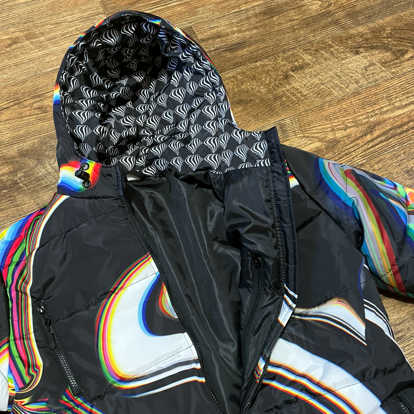 Black winter coat by Drip Drop Labs, featuring a sleek design and insulated fabric for cold weather warmth.