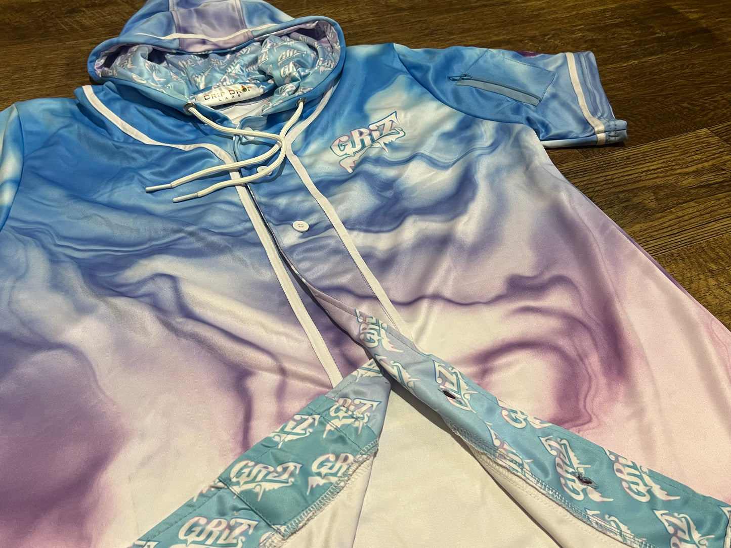 Black hooded baseball jersey from Drip Drop Labs' GrizDrip v5 collection, featuring team-style design and logo details.